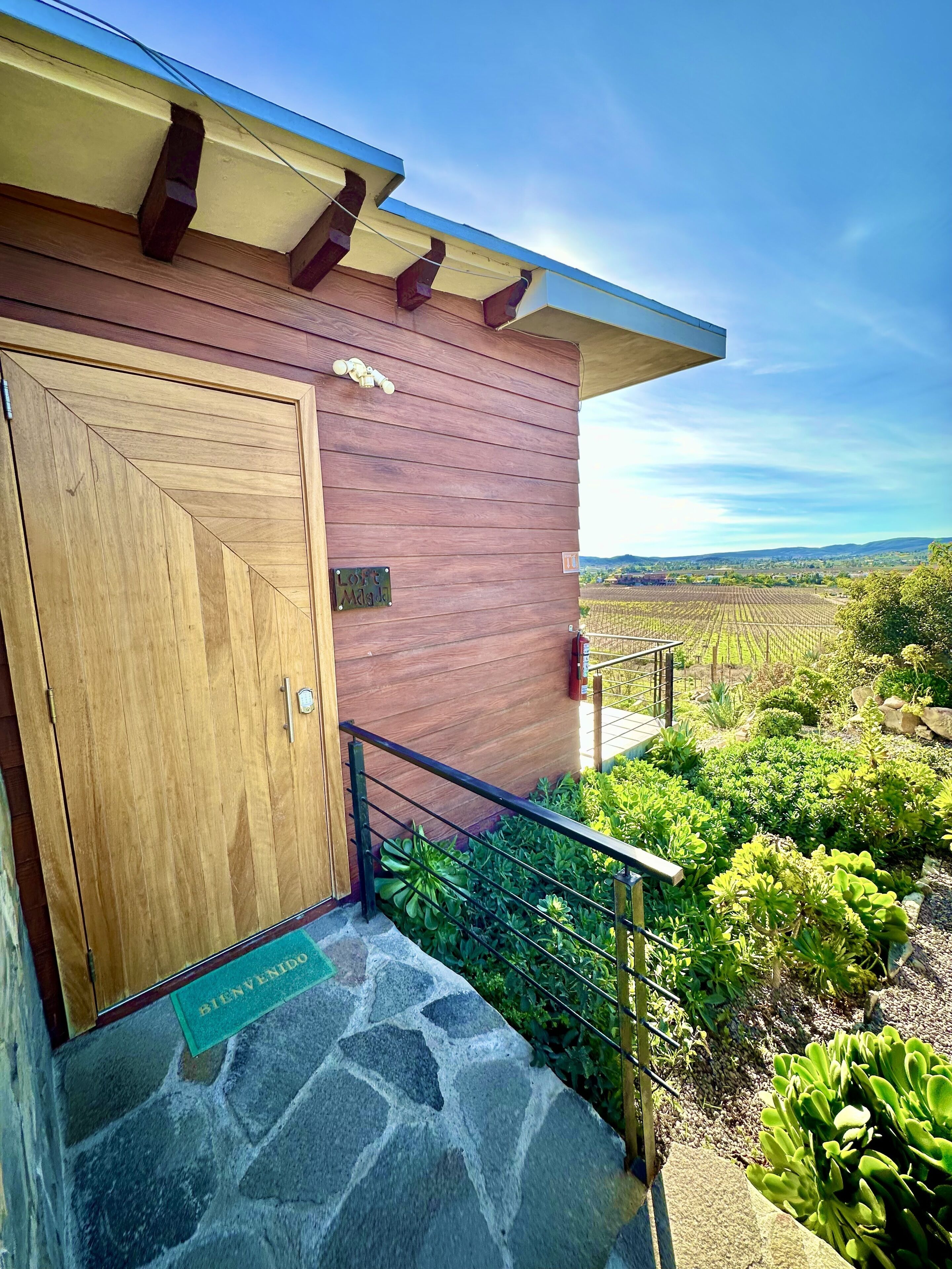 A wooden building with a stone staircase leading to a door marked "Welcome."