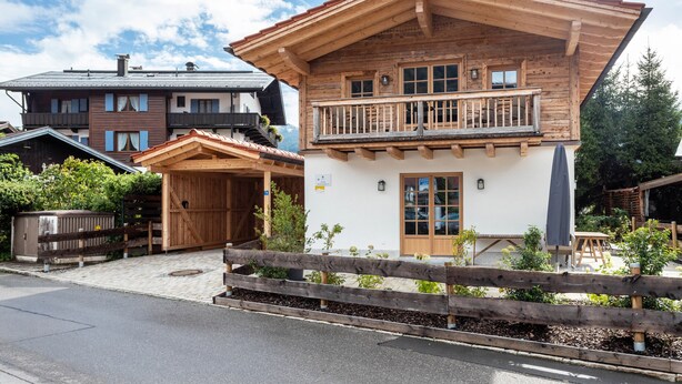A wooden chalet with a balcony, a covered entrance, and a small garden area. - 'Chalet Kaisereck' with Terrace & Wi-Fi (Reit im Winkl)