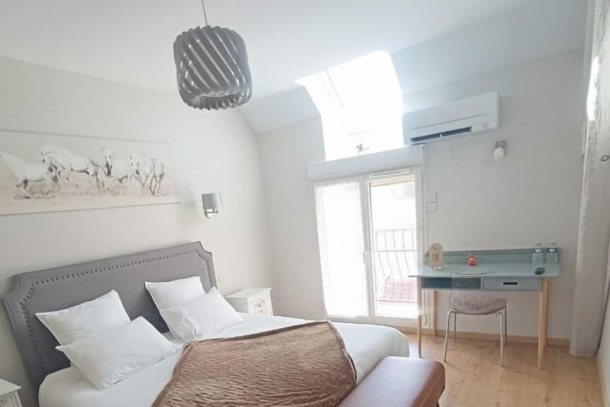 Een slaapkamer met een bed, een bankje en een pluchen vloerkleed.