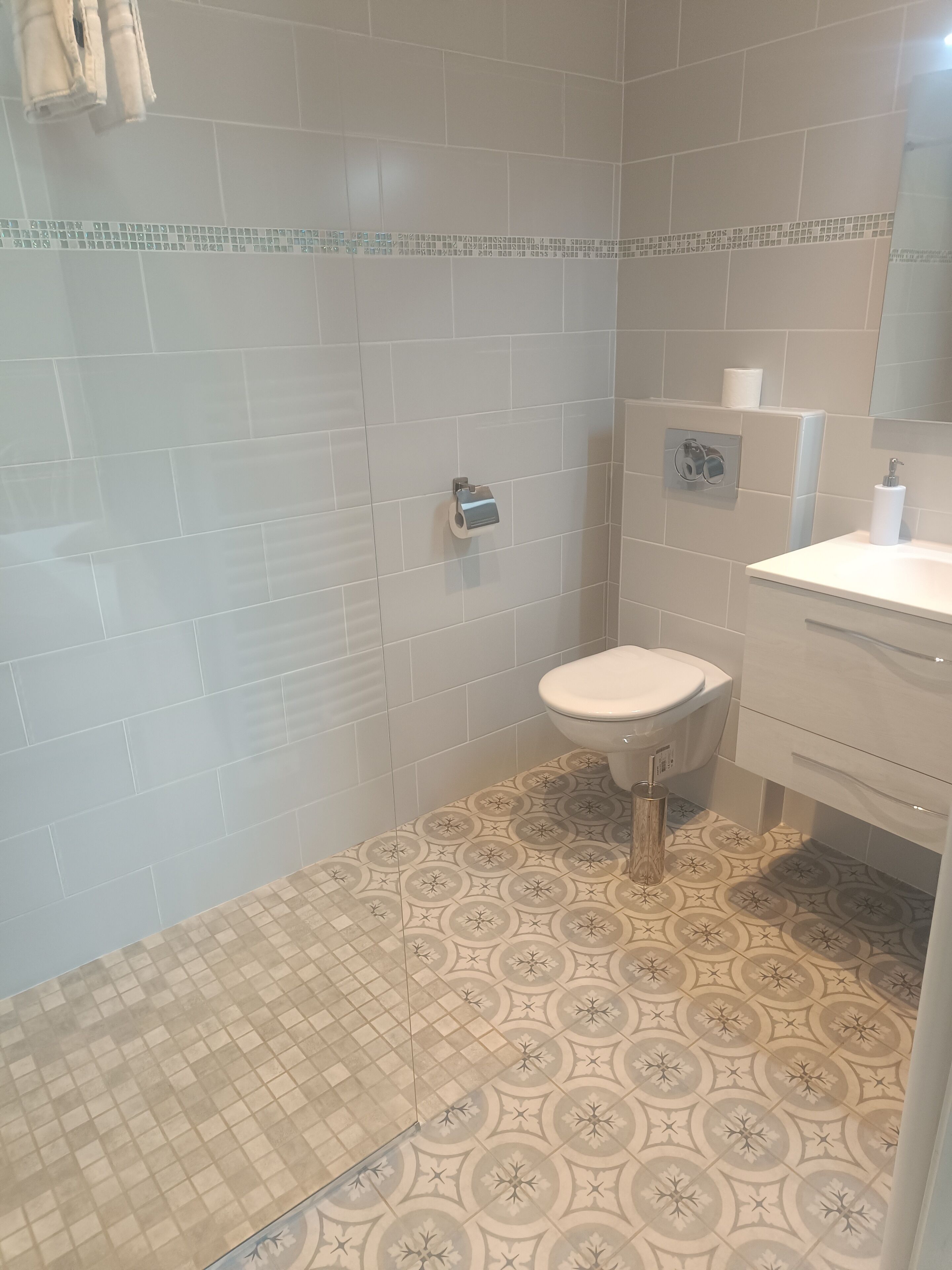 Ein Badezimmer mit Toilette, Waschbecken und Duschbereich.