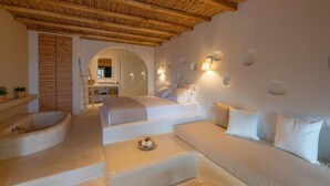 Um quarto moderno com uma cama grande, um sofá e uma banheira.