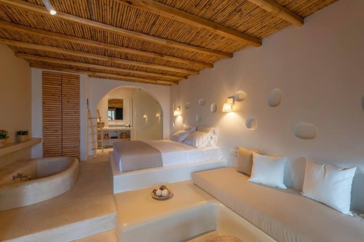 Un dormitorio moderno con una cama grande, un sofá y una bañera.