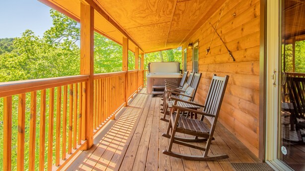 Eine Holzterrasse mit Schaukelstühlen und einem Whirlpool.