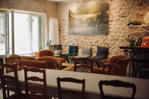 Un comedor con pared de piedra, un cuadro y una mesa con sillas.