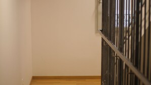 A hallway with wooden flooring and a metal railing.