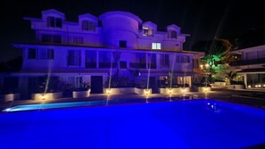 A multi-story building with a swimming pool in front. - Oludeniz Evleri (Fethiye)