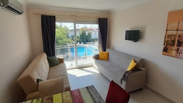 Condo luxo, vista para a piscina | Área de estar | TV de tela plana 80 cm com canais via satélite