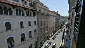 A street view of a city with buildings featuring arched windows and balconies. - Sistina36 Spanish Steps Apartment (Roma)