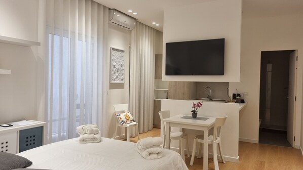 Relax in a spacious room with a large bed, flat-screen TV, and sink.
