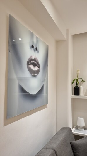 Contemporary space with a large artwork and a grey sofa.