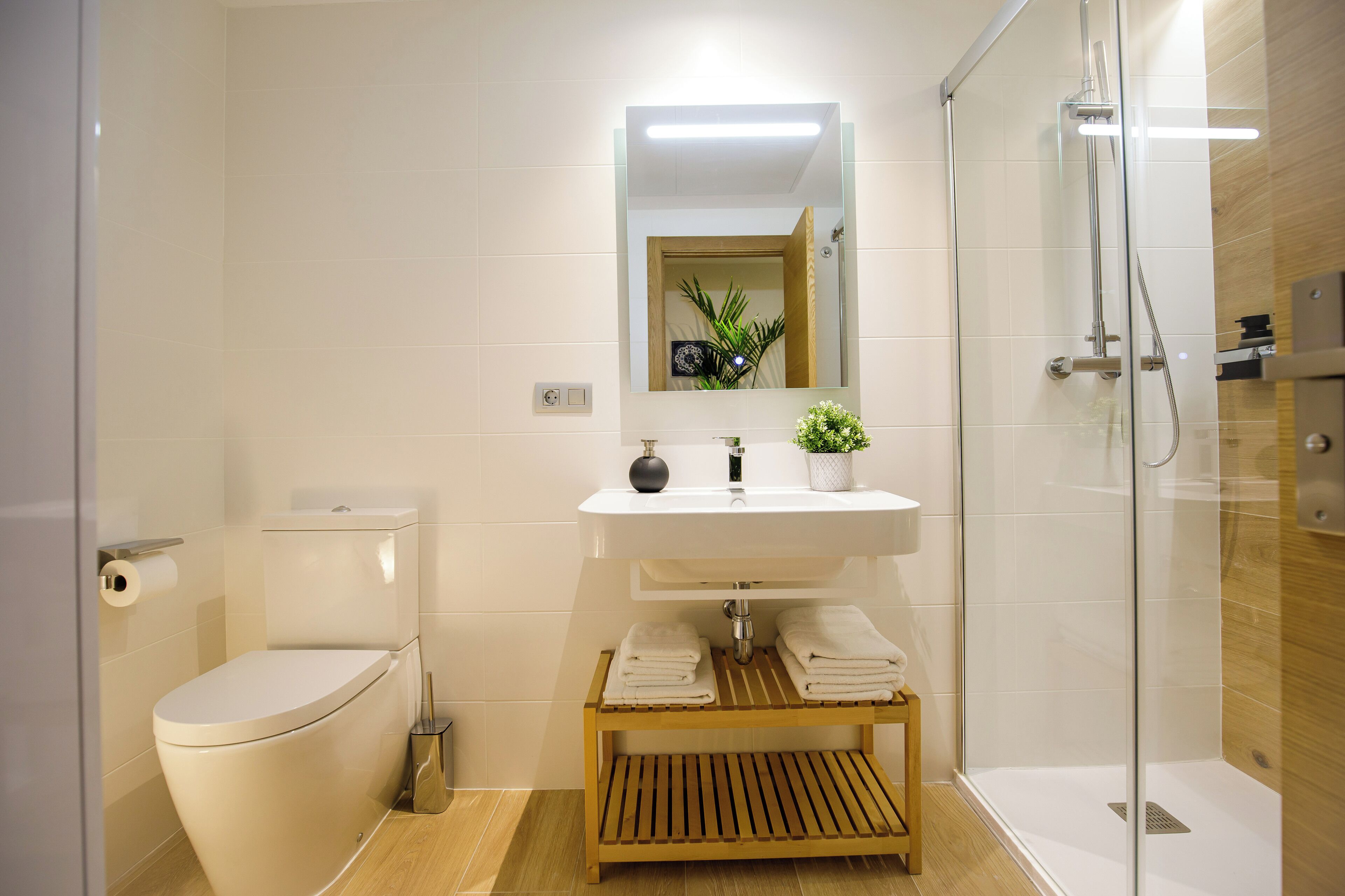 A modern bathroom with a toilet, sink, and shower.