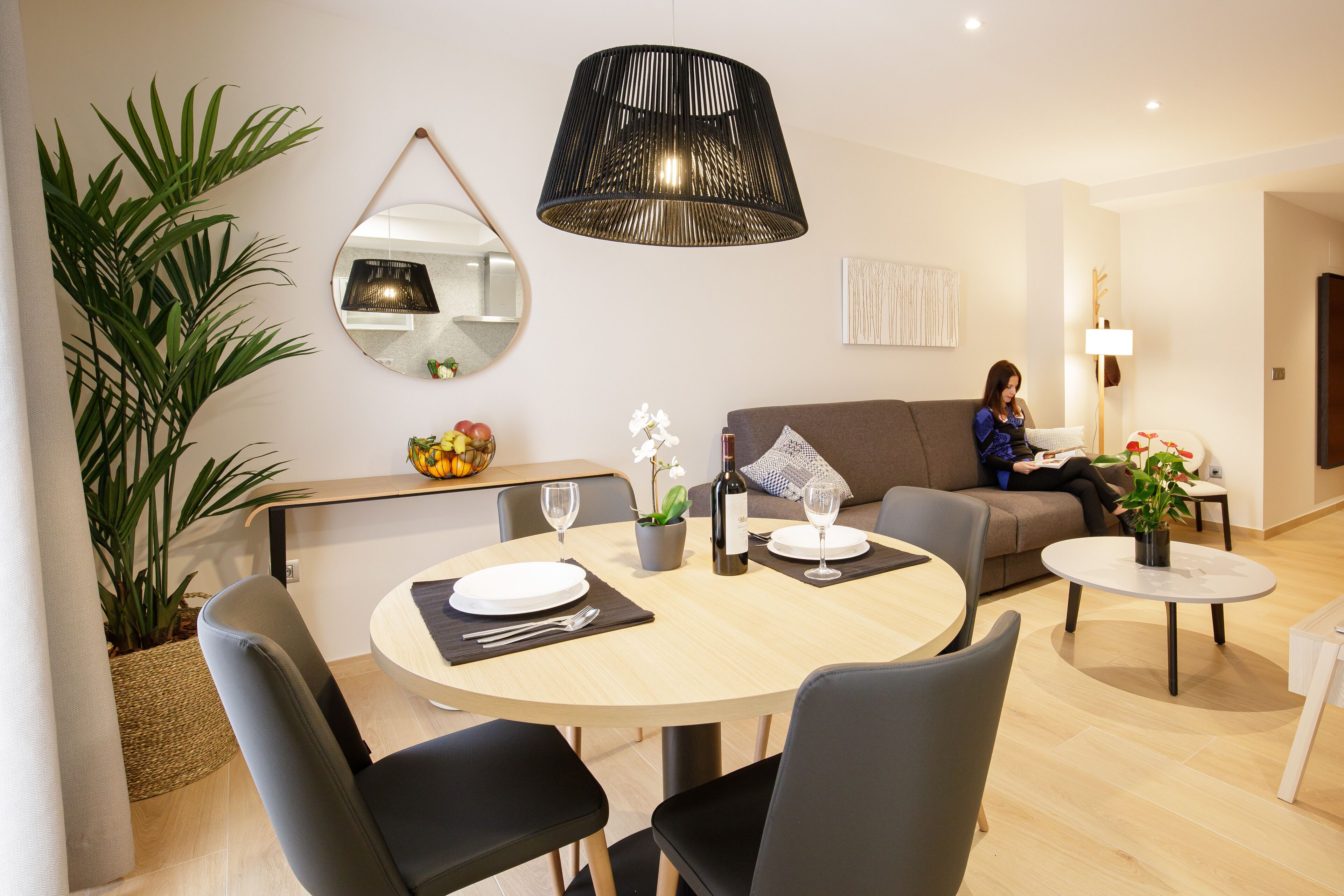 Una sala de estar moderna con comedor, que incluye una mesa redonda, sillas, un sofá y una mesa de centro.