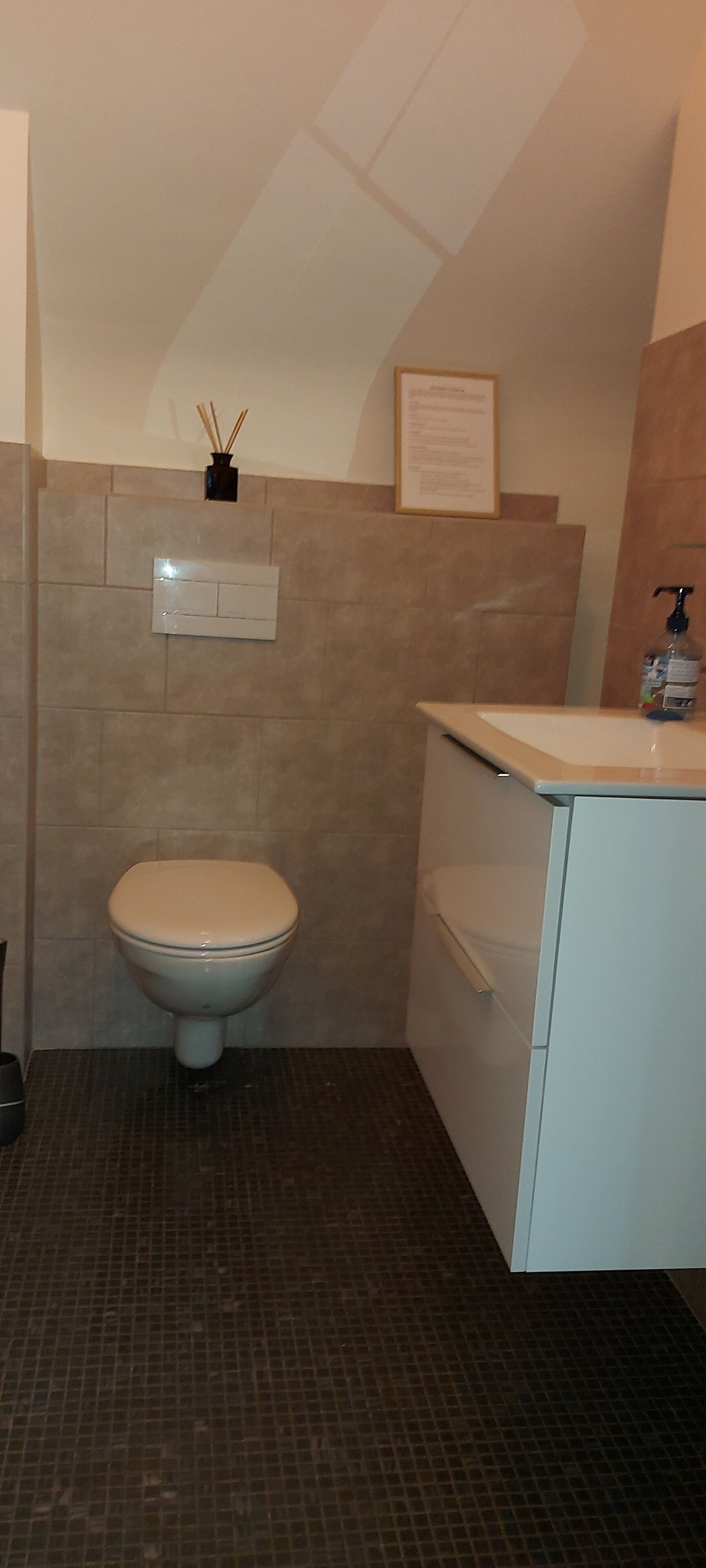 A small bathroom with a toilet, a sink, and a cabinet.