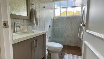 Chuveiro, toalhas de banho, papel higiênico