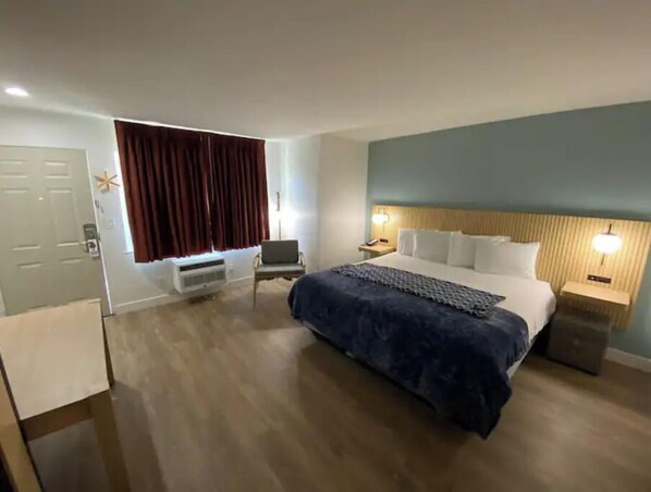 Relax in a spacious room with a large bed, comfortable seating area, and ample natural light.