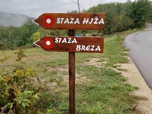A wooden directional signpost with two arrows pointing in opposite directions, labeled "Staza HJŽA" and "Staza Breza". - Stara Hiža Vlašić (Žumberak)