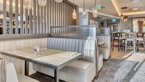 A restaurant with booths, hanging pendant lights, and a patterned carpet. - Premier Inn London Canary Wharf - Westferry (London)