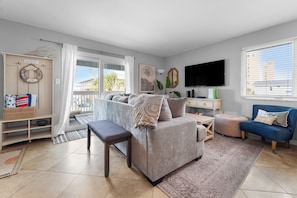 Relax in this inviting living space with a sofa, armchair, and flat-screen TV.
