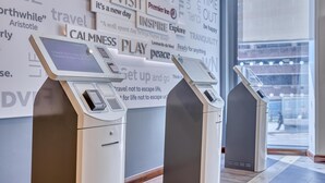 Self-service kiosks in a hotel lobby with motivational phrases on the wall. - Premier Inn Birmingham Cc Exchange Square (Birmingham)