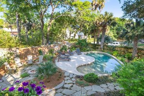 A backyard with a swimming pool, stone pathway, and outdoor seating area. - SERENITY SHORES Private Luxury 5-Level Tropical Oasis, Pool, Steps to Beach (Folly Beach)