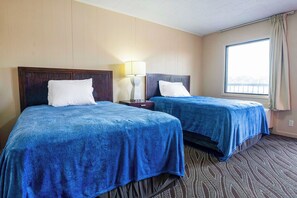 A hotel room with two beds, a nightstand, a lamp, and a window with curtains. - OYO Hotel Opp AL Floral Hwy (Opp)