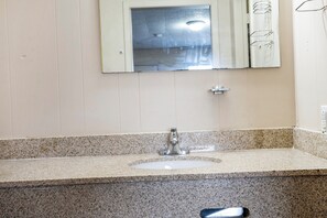 A bathroom with a granite countertop, a sink, and a mirror. - OYO Hotel Opp AL Floral Hwy (Opp)