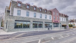 Un immeuble à plusieurs étages, doté d’une façade en pierre, de grandes fenêtres et d’une enseigne bien visible indiquant « Premier Inn ».