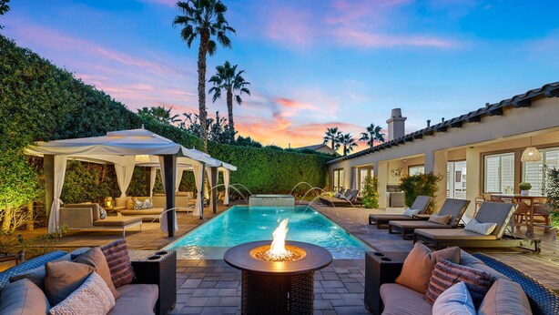 A pool area with a fire pit, lounge chairs, and a covered seating area. - The Rose at Montage - Ultimate Estate (Indio)