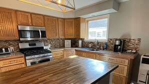 Una cocina moderna con armarios de madera, electrodomésticos de acero inoxidable y una isla grande.