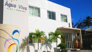 A modern building with a sign reading "Água Viva Flat / Pousada". - Pousada Agua Viva (Ipojuca)