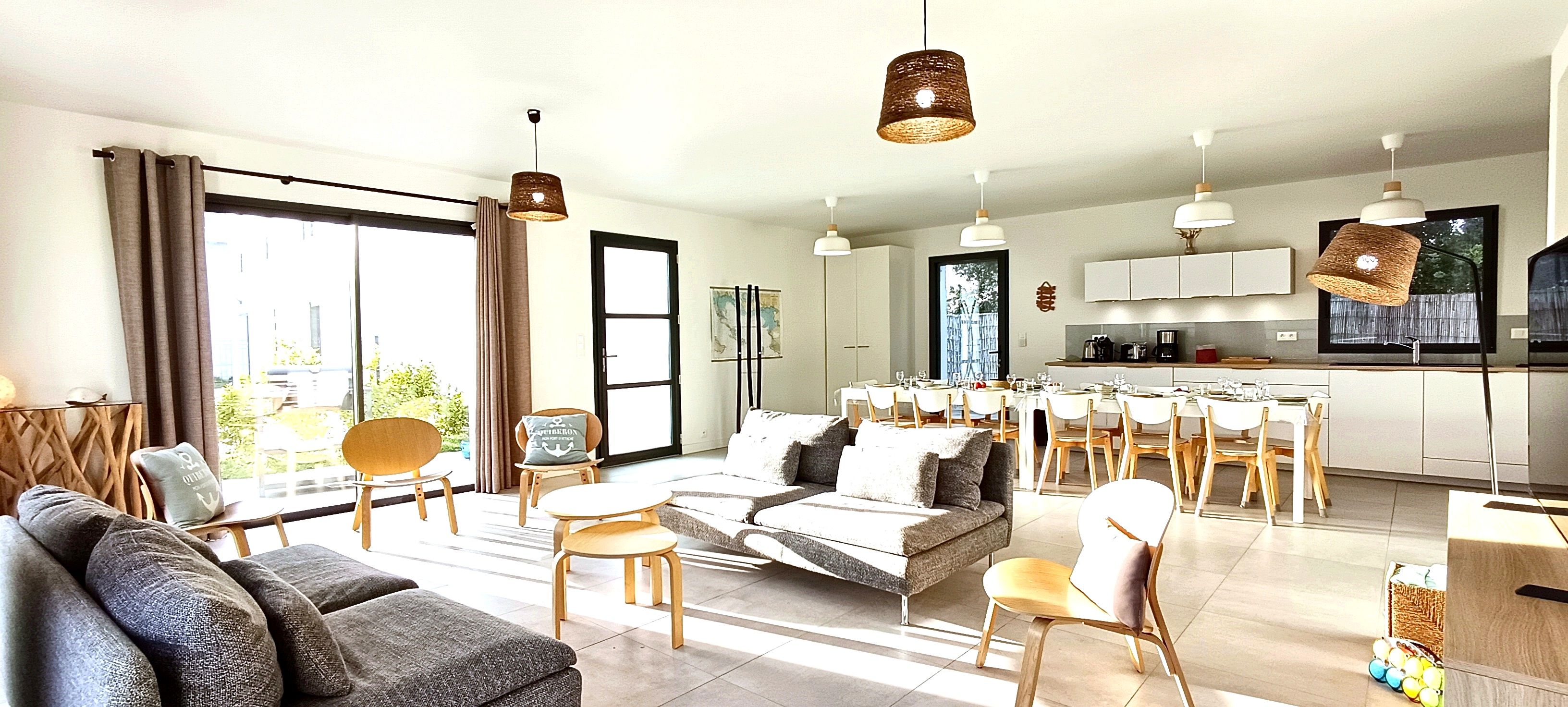 A modern living room with a sofa, chairs, and a dining area with a table and chairs.