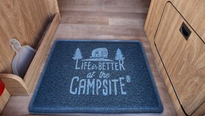 Interni di un camper con zona pranzo, due salotti e vista sull'esterno.