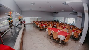 A spacious conference room with rows of tables and chairs, large windows, and a modern design. - Imperio Romano Thermas Hotel -BVTUR (Caldas Novas)
