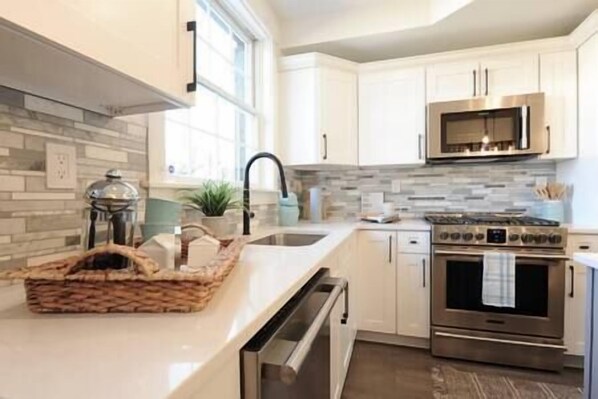 Enjoy cooking in this well-equipped kitchen with a large island, oven, and modern sink.