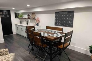 Enjoy meals in this kitchen with a dining table for four, a blackboard, and modern cabinetry.