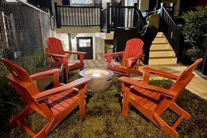 Relax in an outdoor space with a fire pit and Adirondack chairs.
