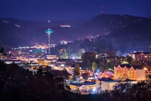 A town at night with illuminated buildings and a prominent tower. - PROMO 10% WEEKLY DISCOUNT
Family Cabin Near Dollywood, Hot Tub, Arcade, Pool (Sevierville)