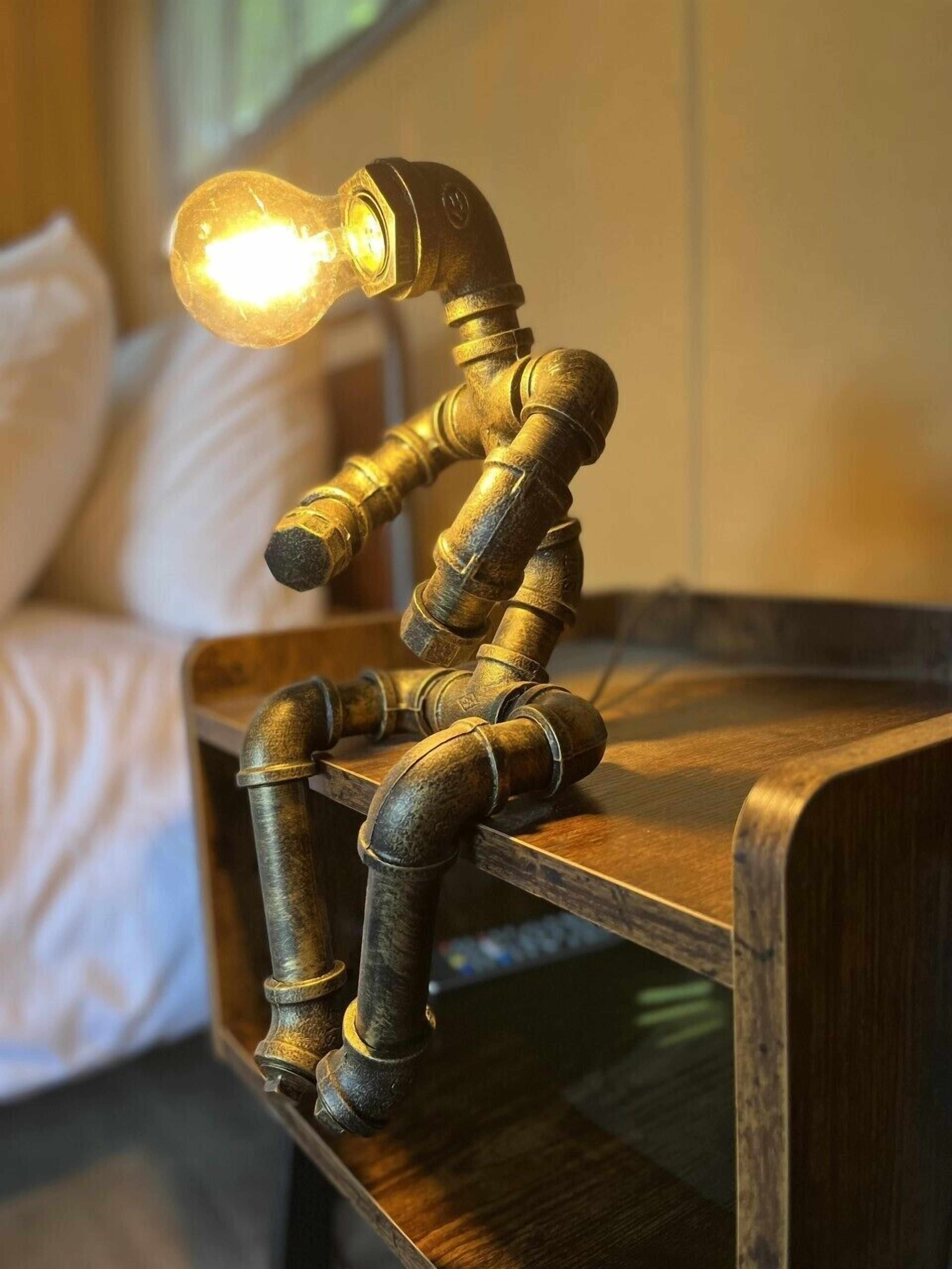 A brass lamp with a bulb on a wooden nightstand.