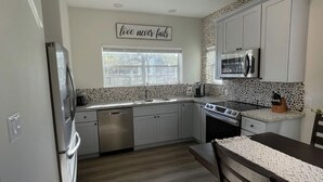 A modern kitchen with white cabinets, a microwave, and a dishwasher. - Country Oasis -B (Hockley)