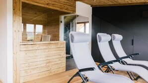 A modern interior with wooden ceiling beams, a reception desk, and two reclining chairs. - Light-flooded dream home between Chiemsee and the Alps (Traunstein)