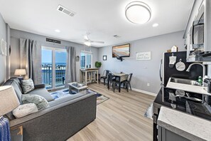 Relax in this spacious living room with a sofa, dining area, and kitchen, offering a view of Fort Morgan.