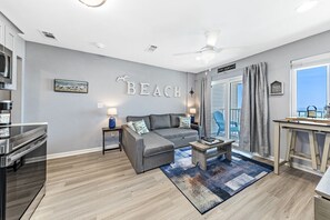 Relax in this stylish living room with a sofa, coffee table, and ocean view.