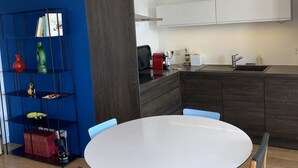 Una cucina moderna con mobili in legno scuro, un piano di lavoro bianco e un forno integrato.