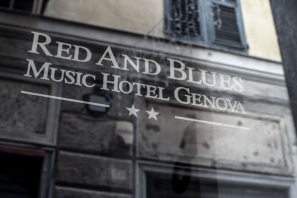 Une enseigne pour l’hôtel Red and Blues Music de Gênes, ornée d’étoiles et de motifs linéaires décoratifs.