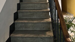 Eine Treppe mit einem Holzgeländer und einer gelben Wand oben.