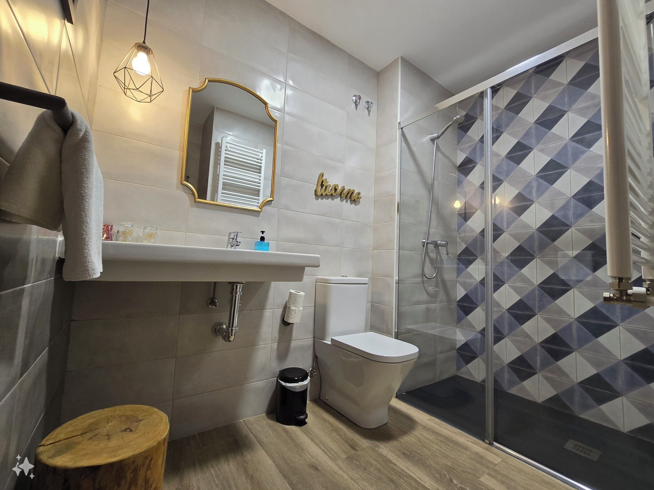 A modern bathroom with a shower, toilet, sink, and a vanity mirror.