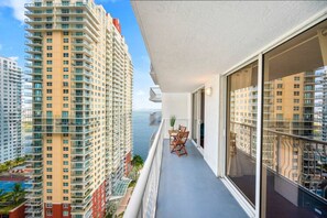 Ein Balkon mit Blick auf hohe Gebäude und ein Gewässer.