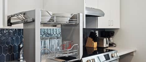 Una cocina moderna con horno empotrado, campana extractora de acero inoxidable y escurreplatos.