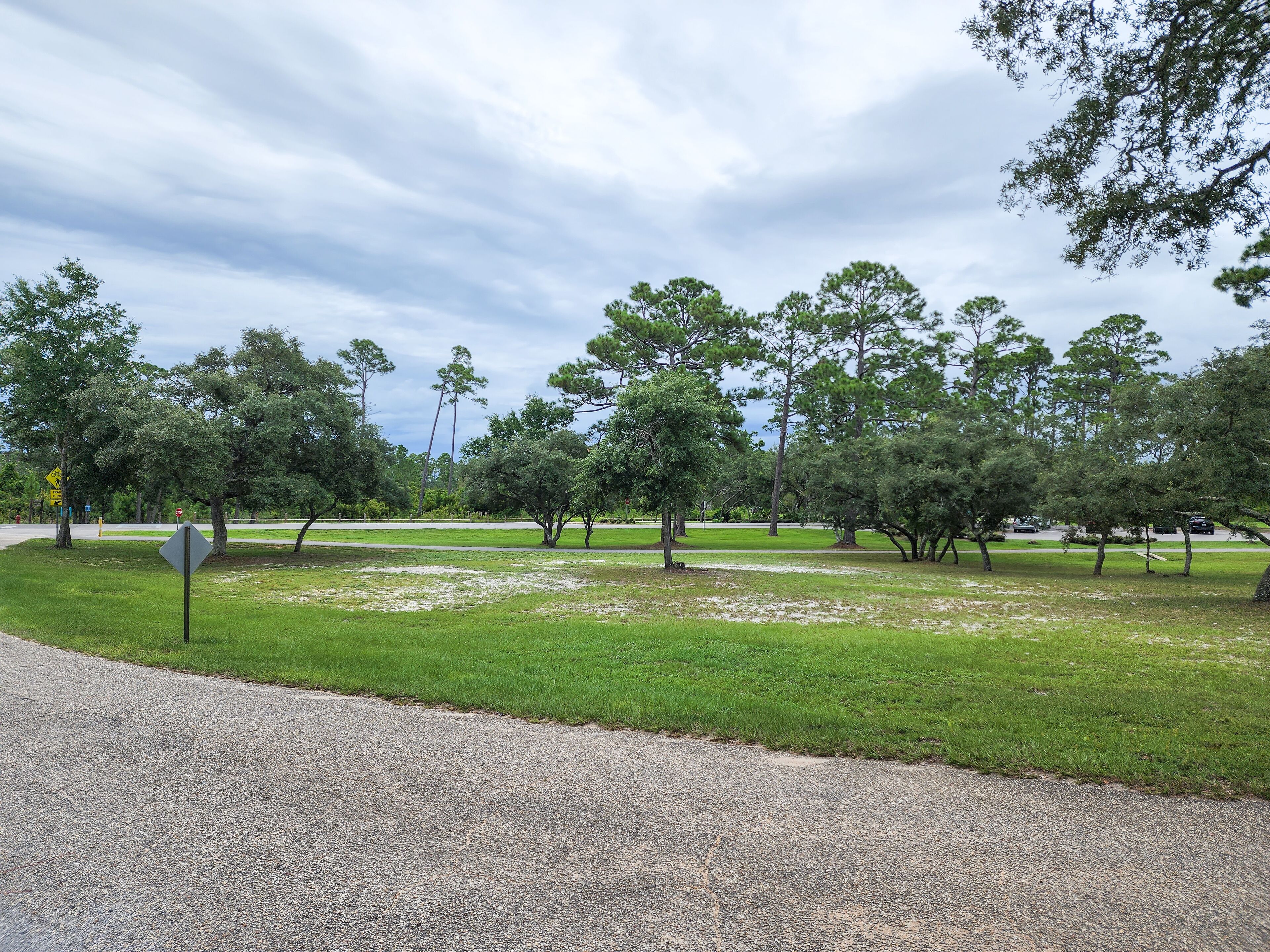 A park with a gravel path, grassy areas, and trees.