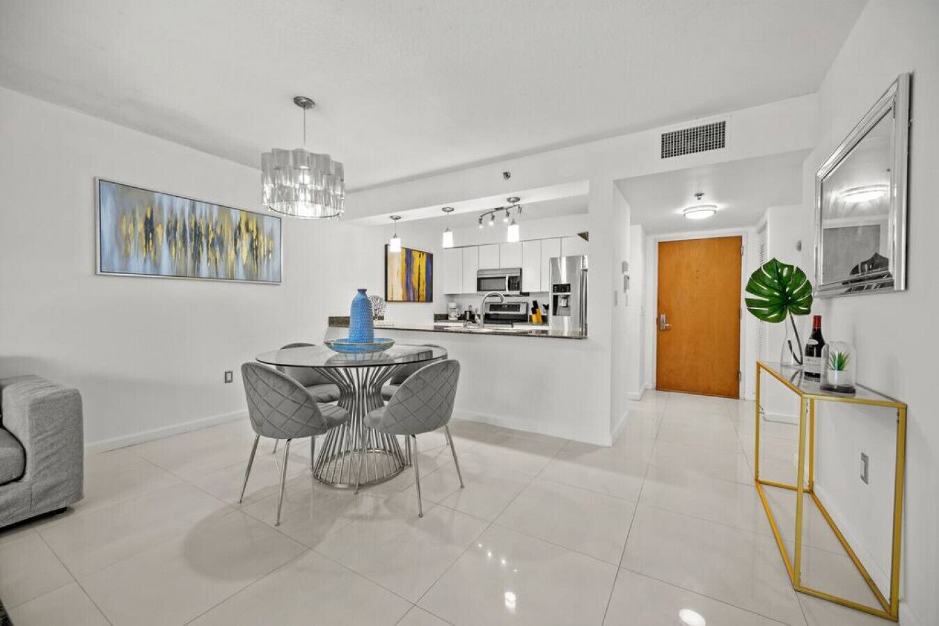A modern kitchen with white cabinets, stainless steel appliances, and a central island.